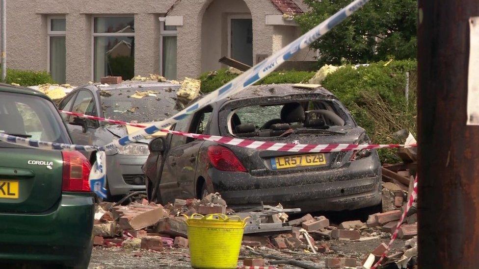 Cars damaged by bricks and debris