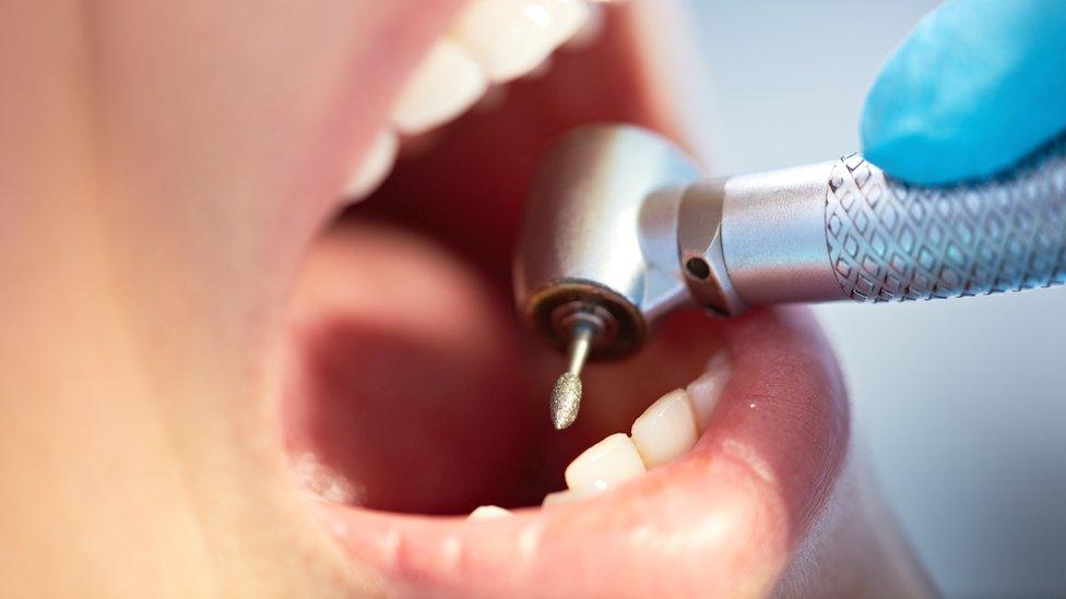 Dentist using drill on patient