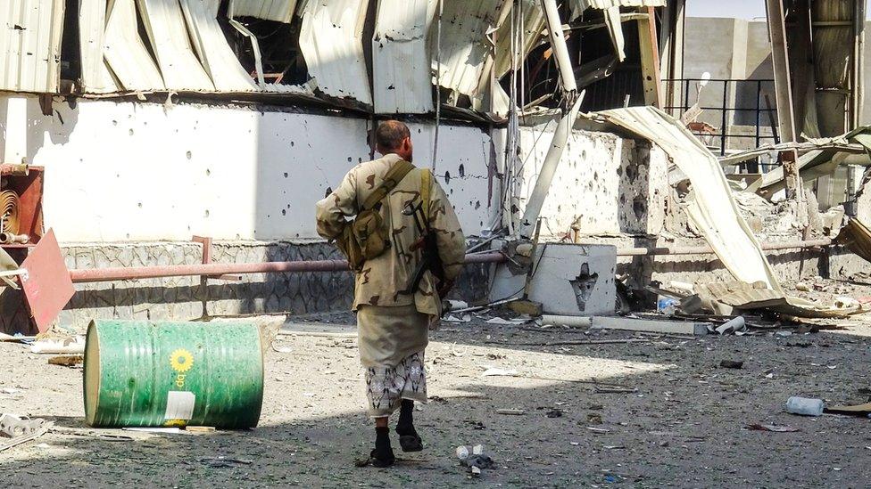 A member of the Yemeni pro-government military walks through an industrial district in the eastern outskirts of the port city of Hudaydah, 18 November 2018