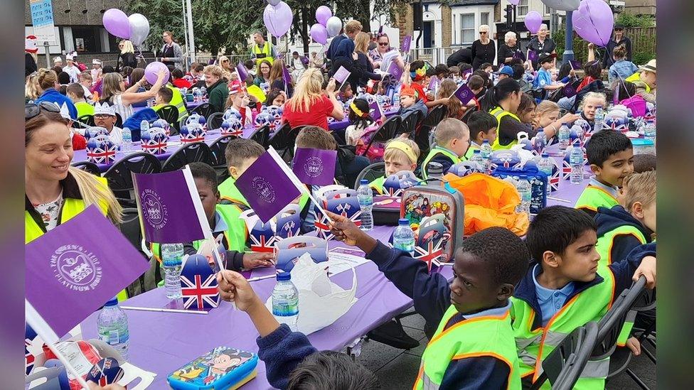 Children wave flags at a street party