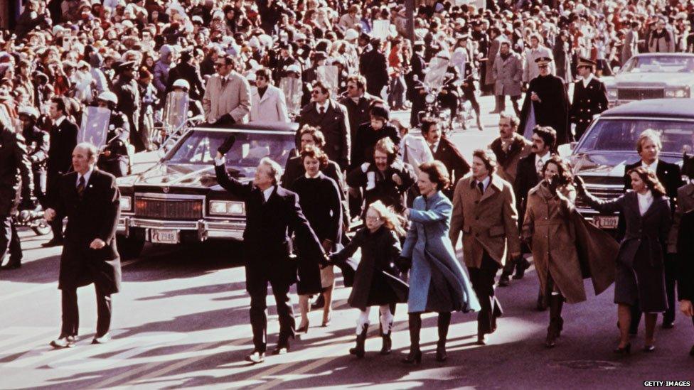 Amy Carter looking delighted at all the attention, holding hands with her parents, President Jimmy Carter and his wife Rosalynn in 1977