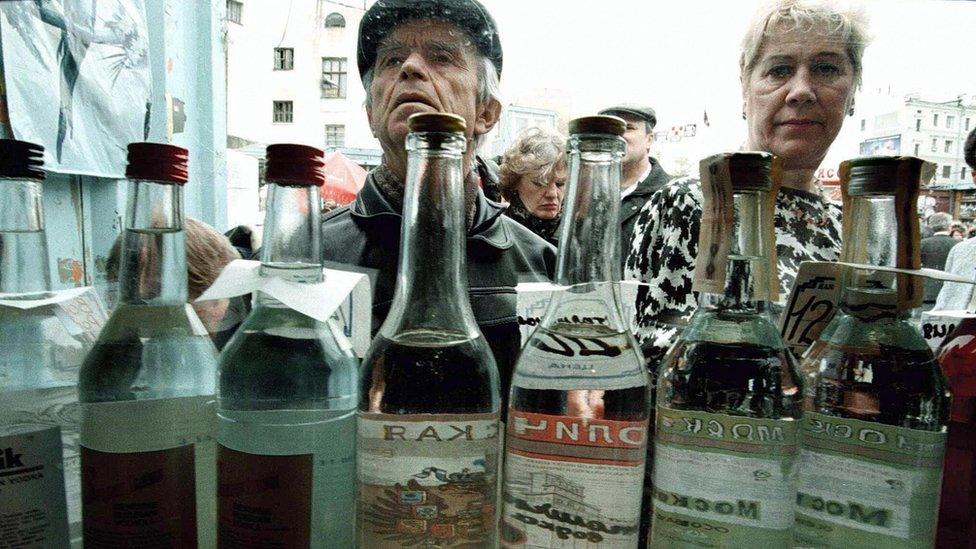 Russians queuing to buy vodka from a street kiosk in Moscow