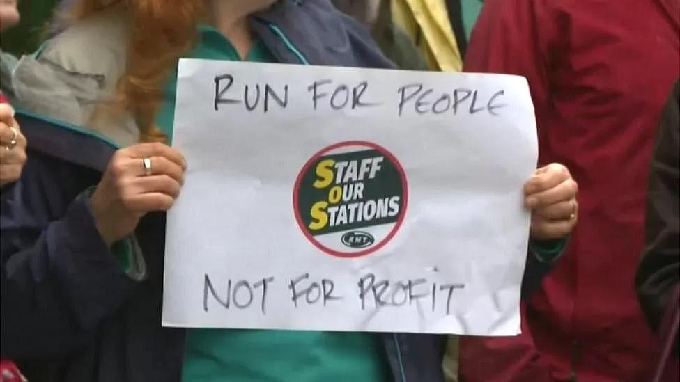 A protester's sign reading 'Run for People - Not for Profit'