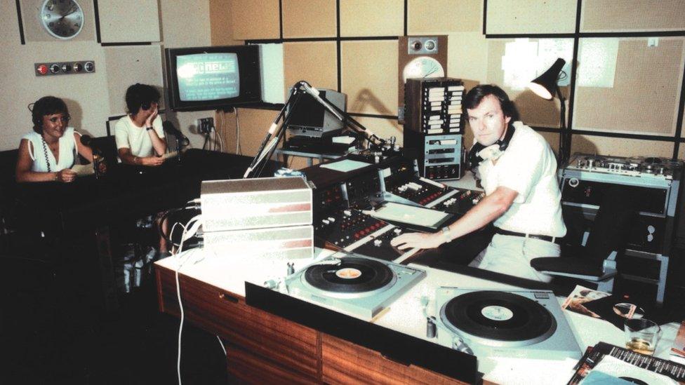 Sam Spindlow is at a mixing desk while Felicity Quevatre and Kay Langlois are sat at microphones