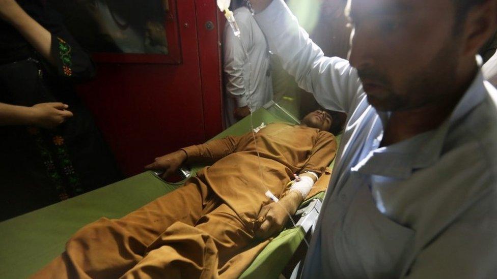 Afghan health workers carry a wounded man who is shifted to the emergency hospital after a car bomb blast targeted a crowd market in Logar province