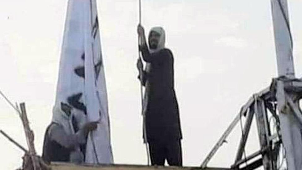 A social media image showing a man raising a Taliban flag