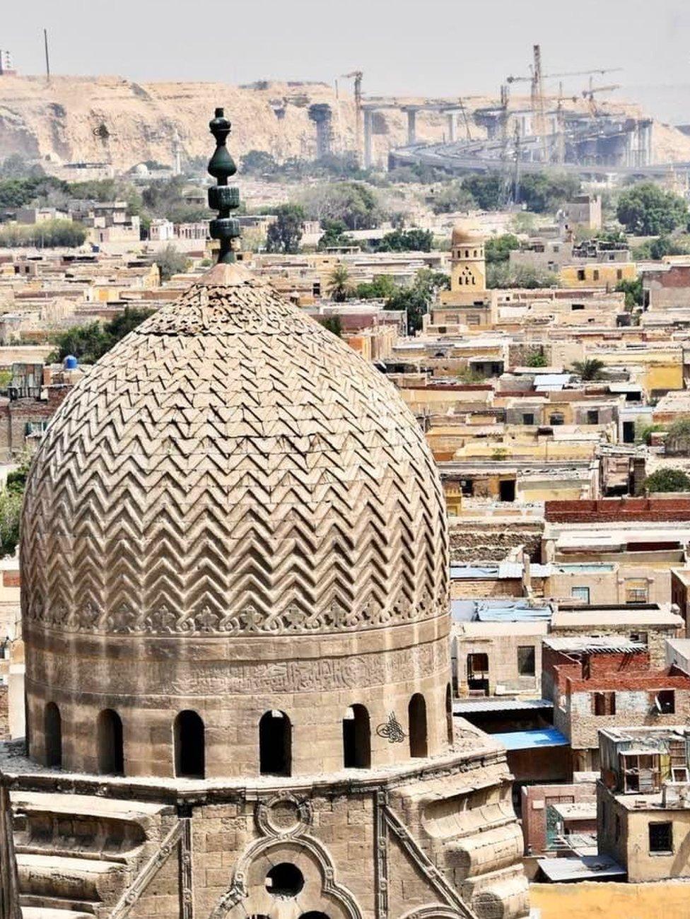 A view of a historic cemetery in Cairo with construction of a bridge in the background