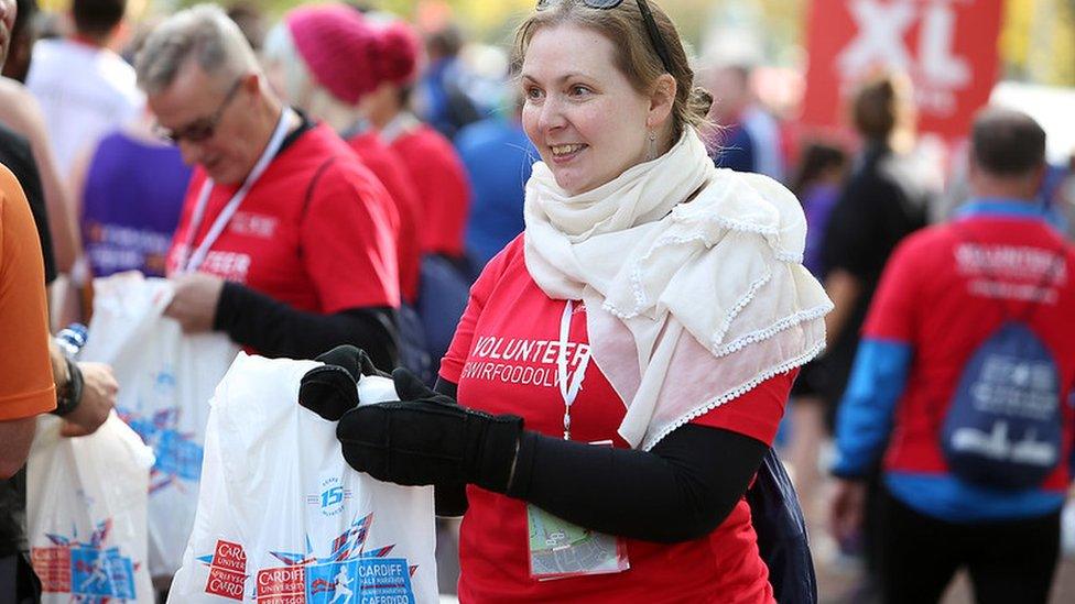 woman handing out bags