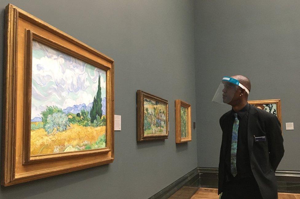 Visor-wearing member of National Gallery staff looking at A Wheatfield, with Cypresses, 1889, by Vincent van Gogh