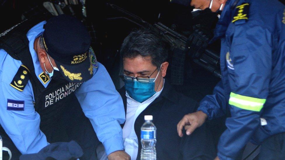 Honduran former President Juan Orlando Hernández (C) is handcuffed at the headquarters of the Honduras Police, 15 February 2022