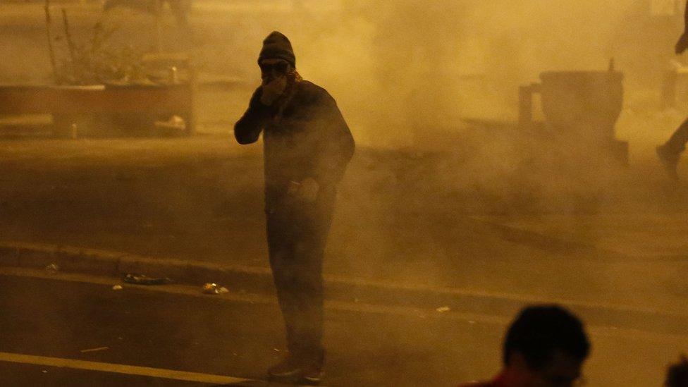 A man covers his mouth with a scarf in thick tear gas, September 4