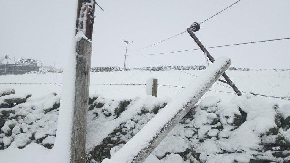 Broken power pole down in the snow