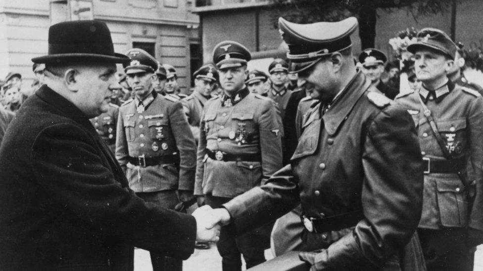 President of Slovakia Jozef Tiso (left) shaking hands with the SS's Hermann Hoefle as he presents him with an award for aiding the fight against Bolshevism, Germany, November 8th 1944.