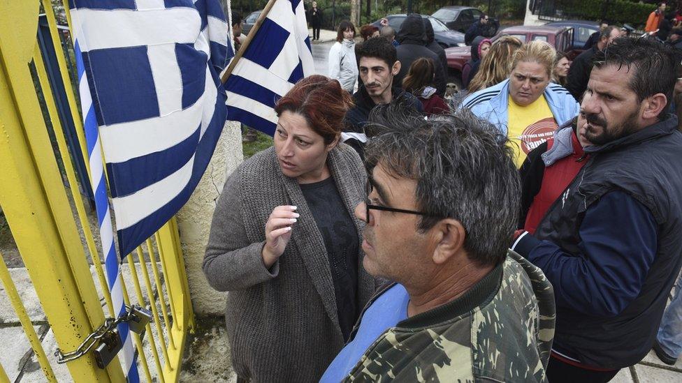 Local residents protest outside a school at the Greek village of Profitis some 35 kilometers (22 miles) east of Thessaloniki, Greece on Monday, Oct. 10, 2016