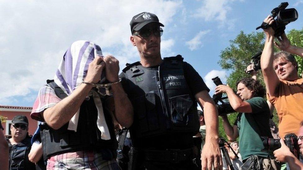 A Greek police officer escorts a Turkish officer who fled to Greece by helicopter after last week's failed coup (21 July 2016)