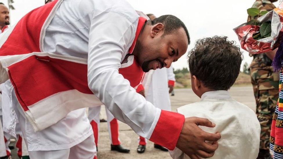 Ethiopia's Prime Minister Abiy Ahmed (C) greets a child as he arrives to welcome Eritrea's President at the airport in Gondar, northern Ethiopia, on November 9, 2018