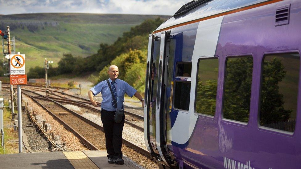 northern rail train with driver standing next to it