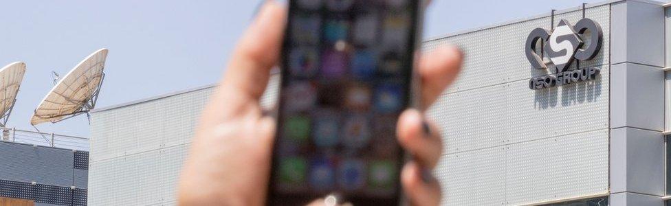 An Israeli woman uses her iPhone in front of the building housing the Israeli NSO group, on August 28, 2016, in Herzliya, near Tel Aviv