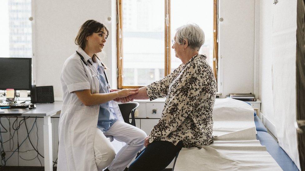 Stock shot of female doctor checking pulse of patient