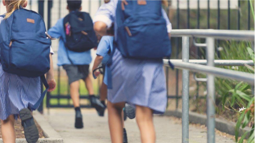 Primary school children with backpacks on