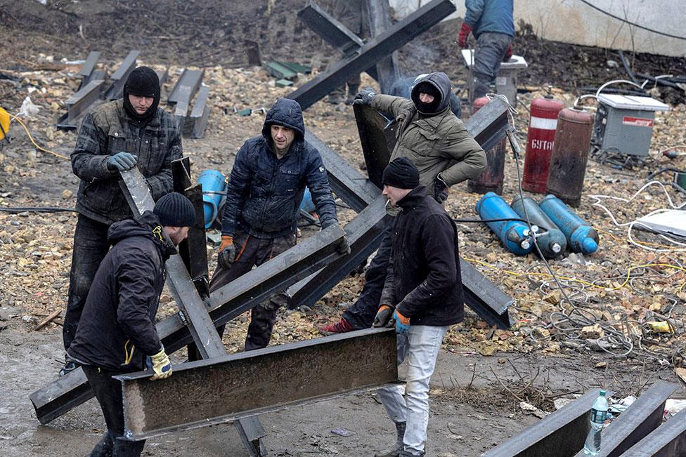 Workers from a local construction company weld anti-tanks obstacles to be placed on roads around Kyiv on 3 March 2022