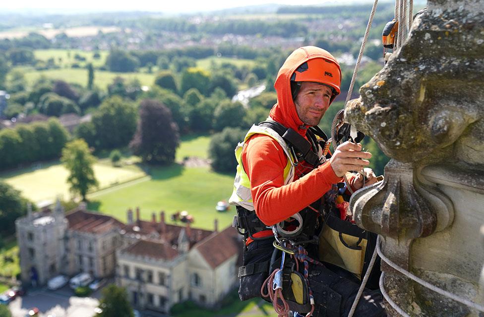 A conservator abseils down the east face of Salisbury Cathedral's Tower