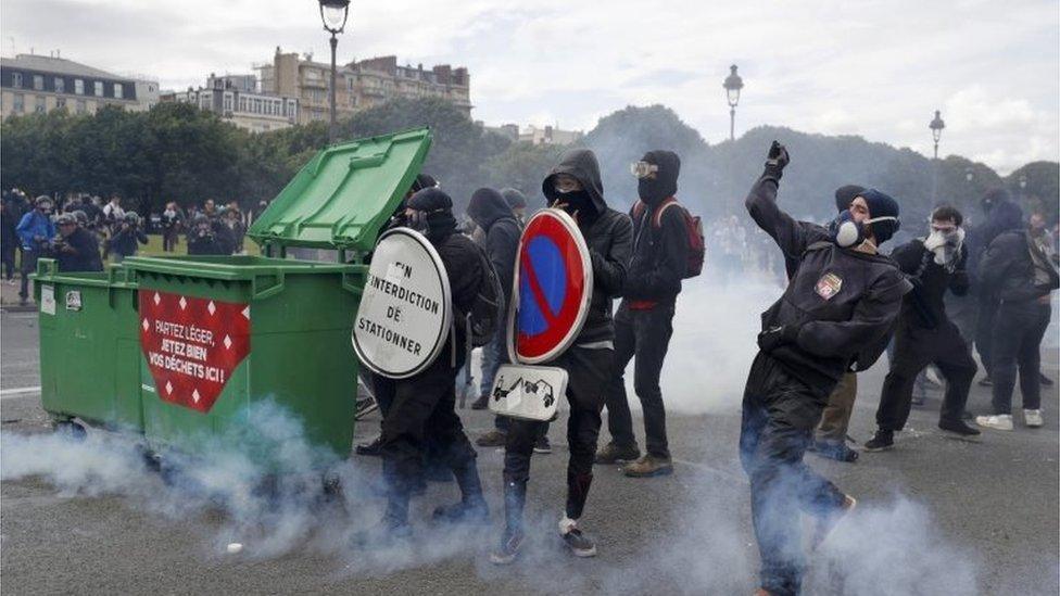 Masked youths face off with French police and gendarmes during clashes at the Invalides square during a demonstration in Paris as part of nationwide protests against plans to reform French labour laws.