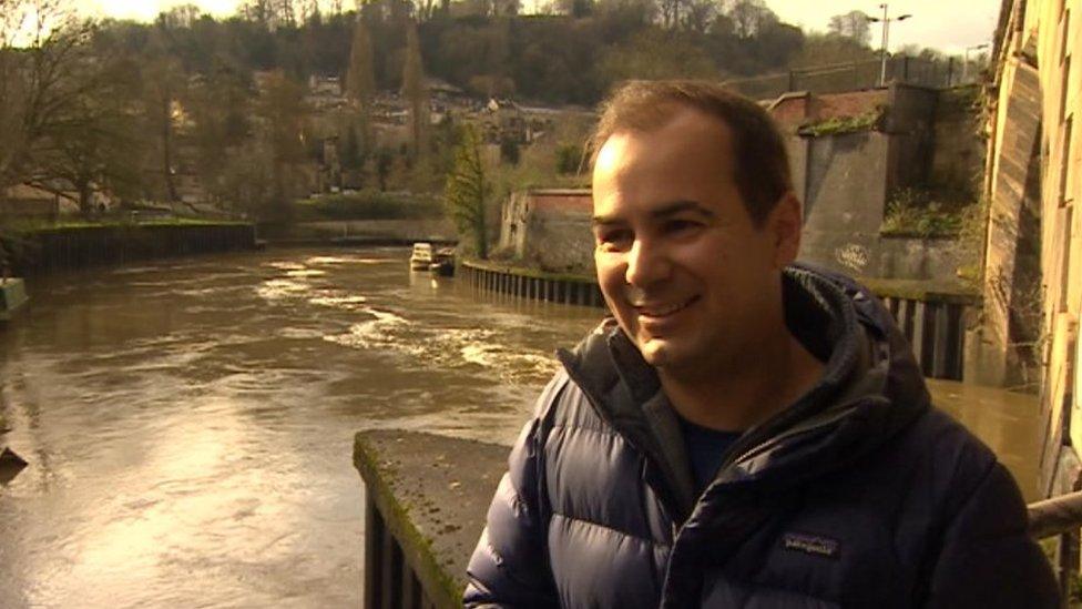 Tom Stephens stands next to the river looking at the camera