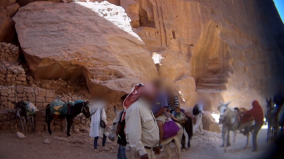 Tourists riding donkeys at Petra, Jordan