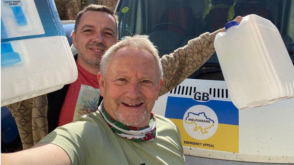 Kev Draper with another volunteer in front of a van holding supplies