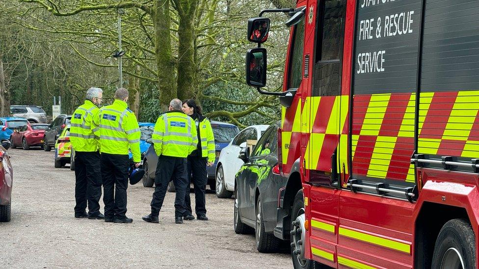 Police officers gathered next to a fire engine