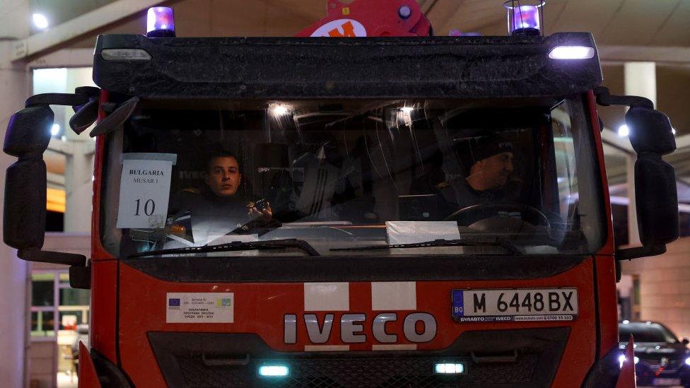 Two men in a fire truck pass a border check