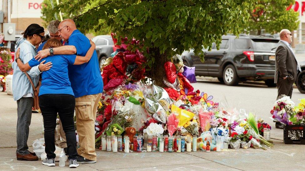 People pray at a memorial at the scene of a weekend shooting at a Tops supermarket in Buffalo, New York, U.S. May 20, 2022.