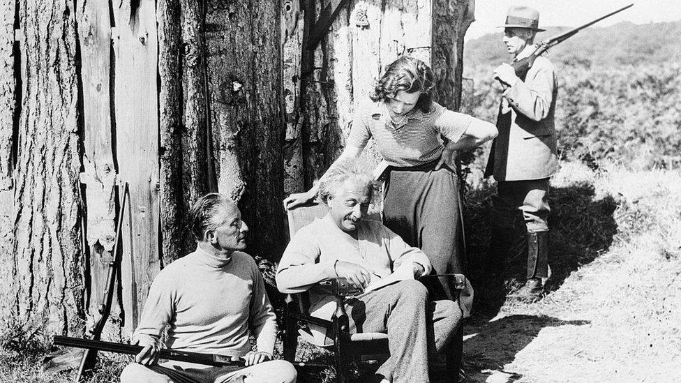 Albert Einstein with Oliver Locker-Lampson and his secretary under armed guard outside his log cabin in Roughton Heath, Norfolk