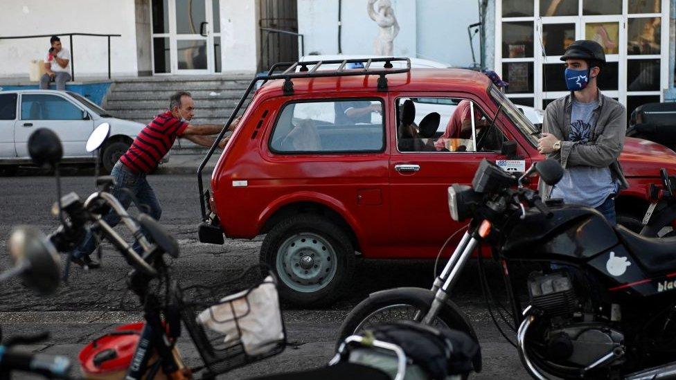 People queue to by fuel at a gas station in Havana