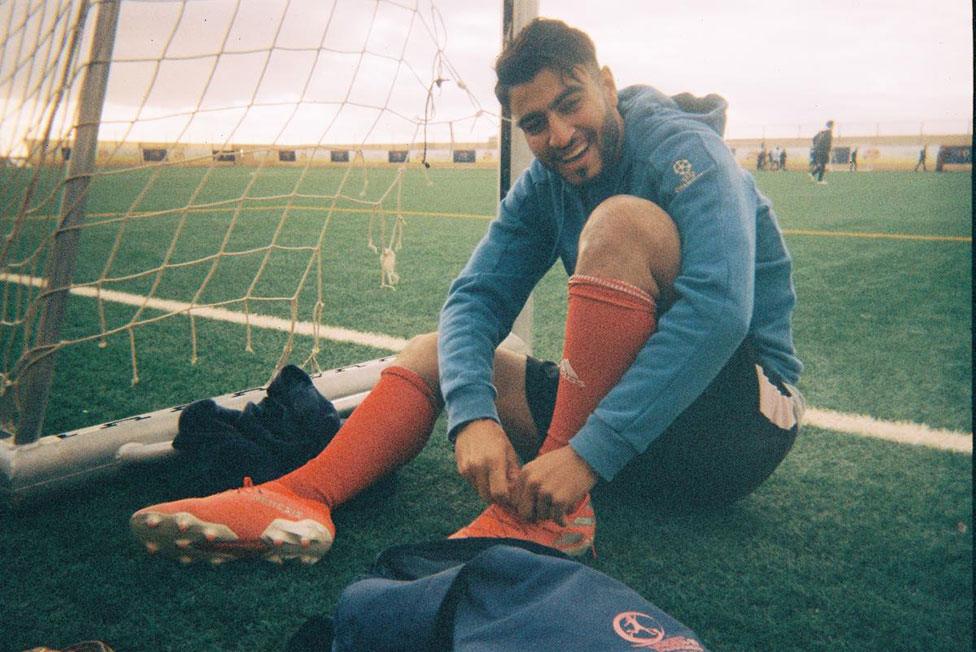 A football player puts his boots on