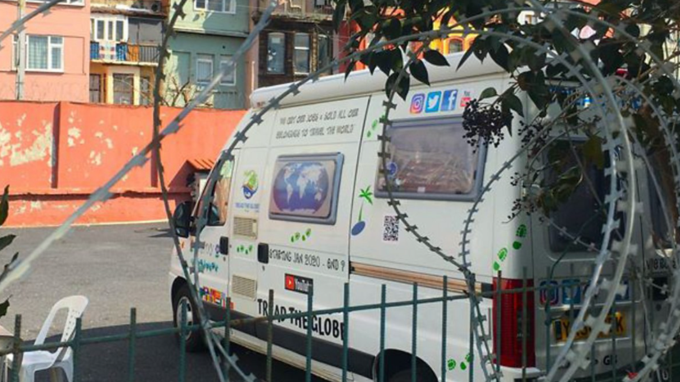 A van in a car park with razor wire