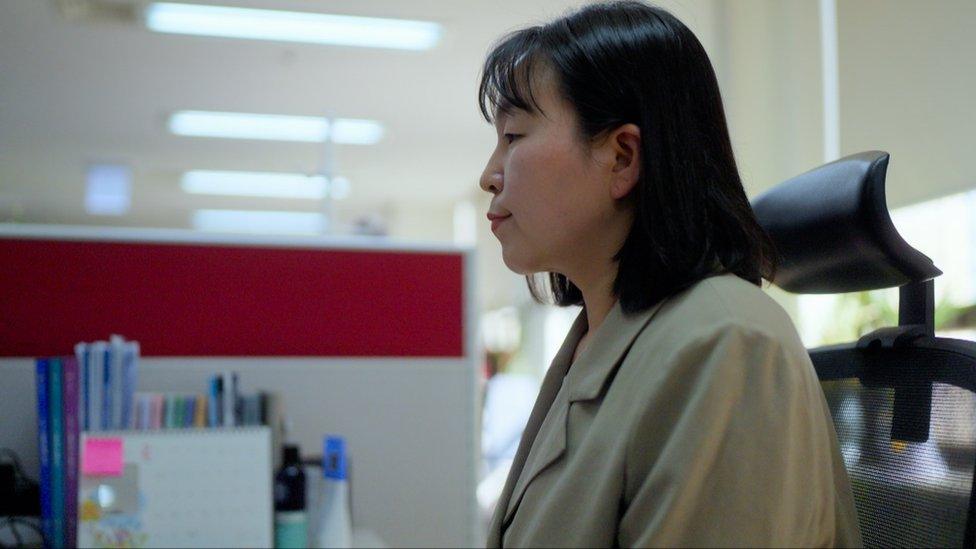 Park Hyo-sil sitting at her desk in the newsroom