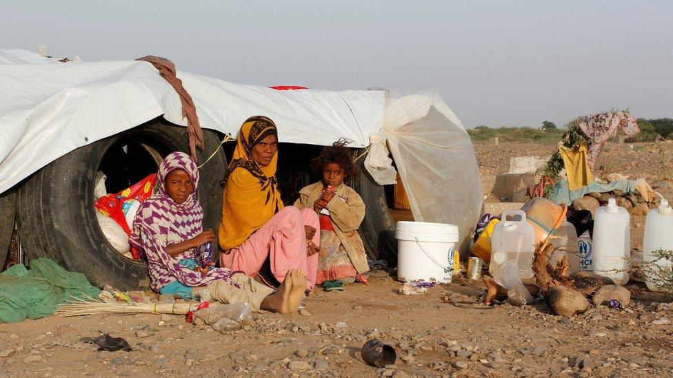 A woman and her daughters sit next to their hut at a makeshift camp for internally displaced people south of the Red Sea port city of Hudaydah, Yemen February 22, 2017