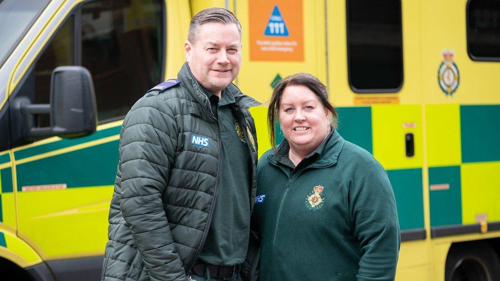 Angie and Steve Mills stood in front of an ambulance