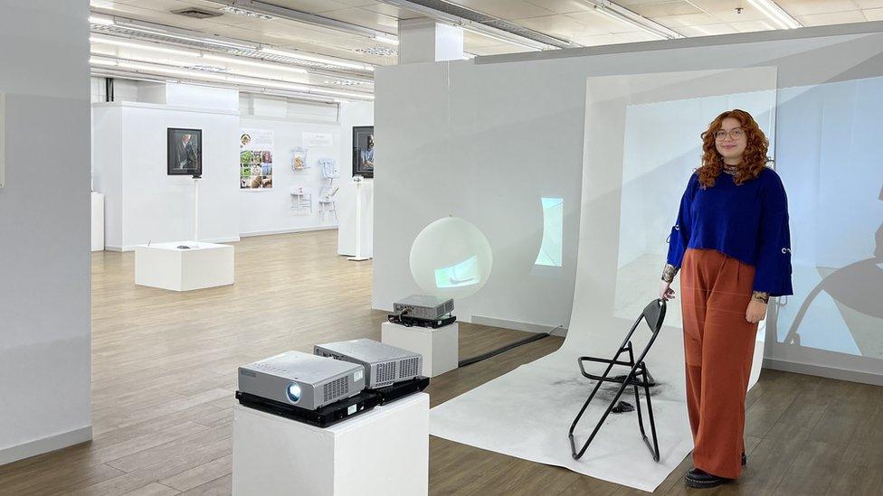 Phoebe Weaver standing in front of her art.