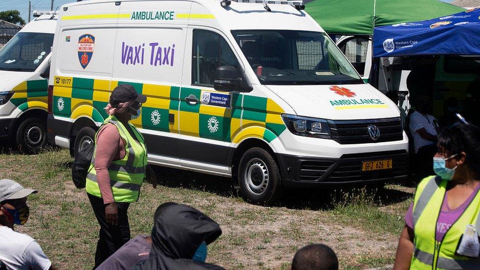 A converted ambulance in South Africa, and people waiting to be vaccinated