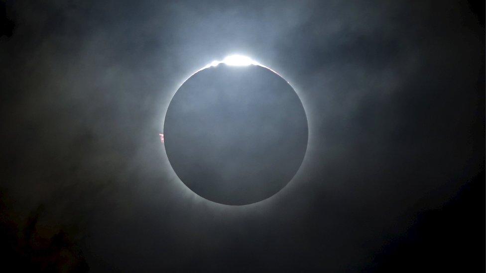 The Sun peeps out around the shadow of the Moon during the total eclipse. This ring of light is called the Corona.