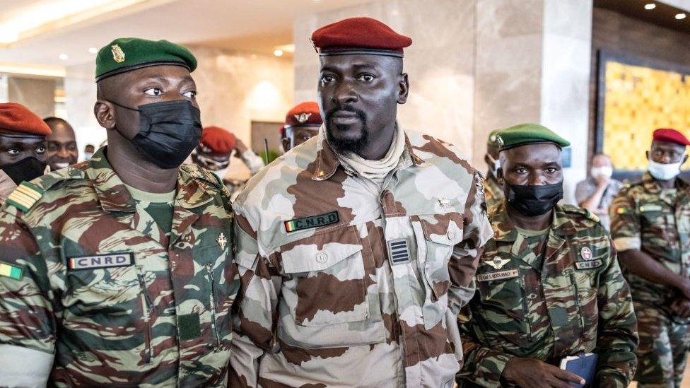 President of the National Committee for Rally and Development (CNRD) Colonel Mamady Doumbouya (C) leaves a meeting with high level representatives of the Economic Community of West African States (ECOWAS) in Conakry on September 17, 2021