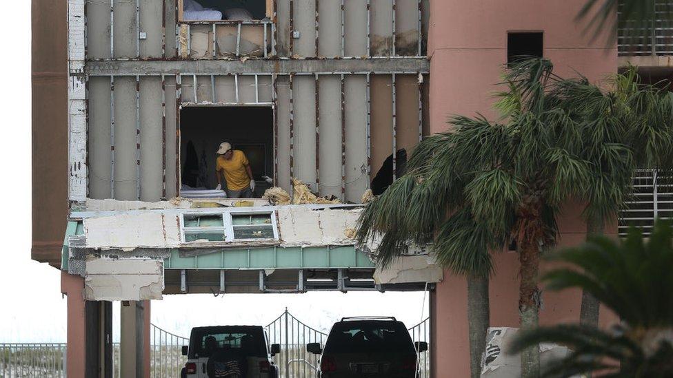 A person is seen in an apartment in the Tropic Isles complex after the outer wall was torn off when Hurricane Sally passed through the area on September 17, 2020 in Gulf Shores, Florida