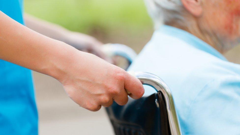 Nurse pushing a patient in a wheelchair