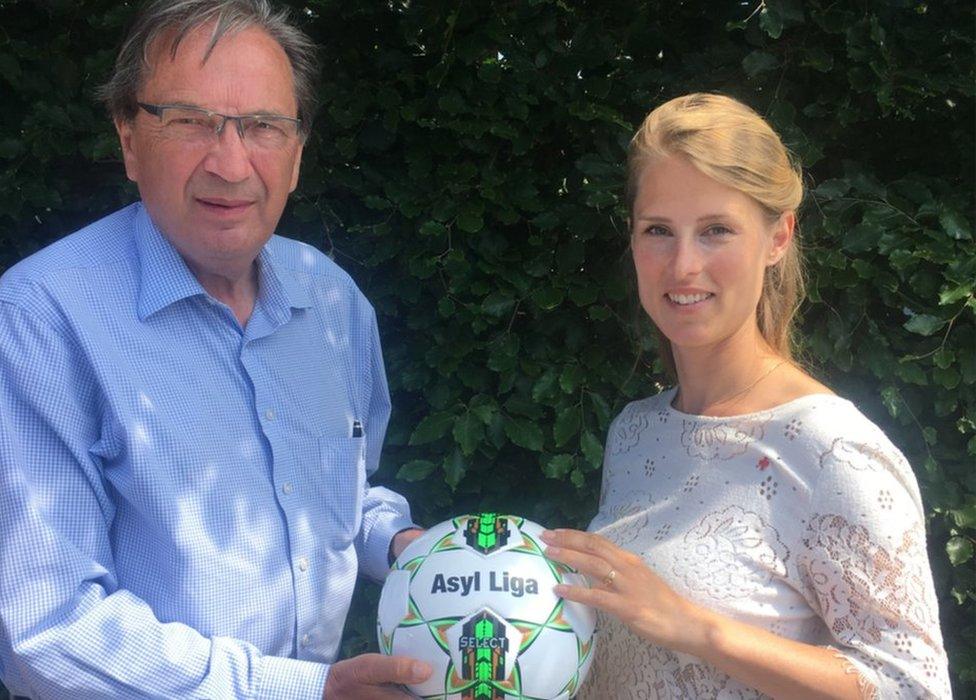 Per Bjerregaard holding an Asylum League football with Danish Red Cross President Hanna Line Jakobsen