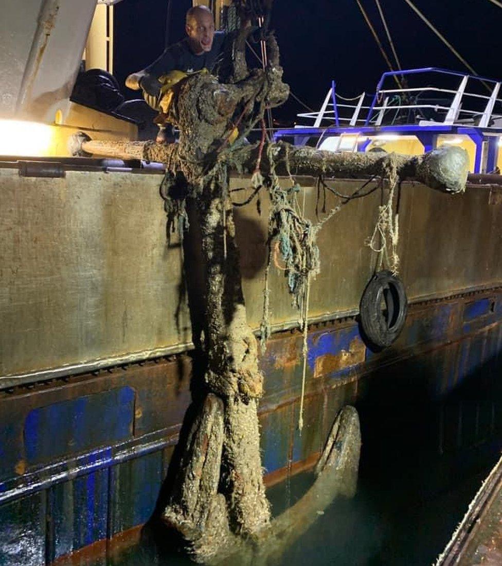 Anchor being hauled up by fishing boat