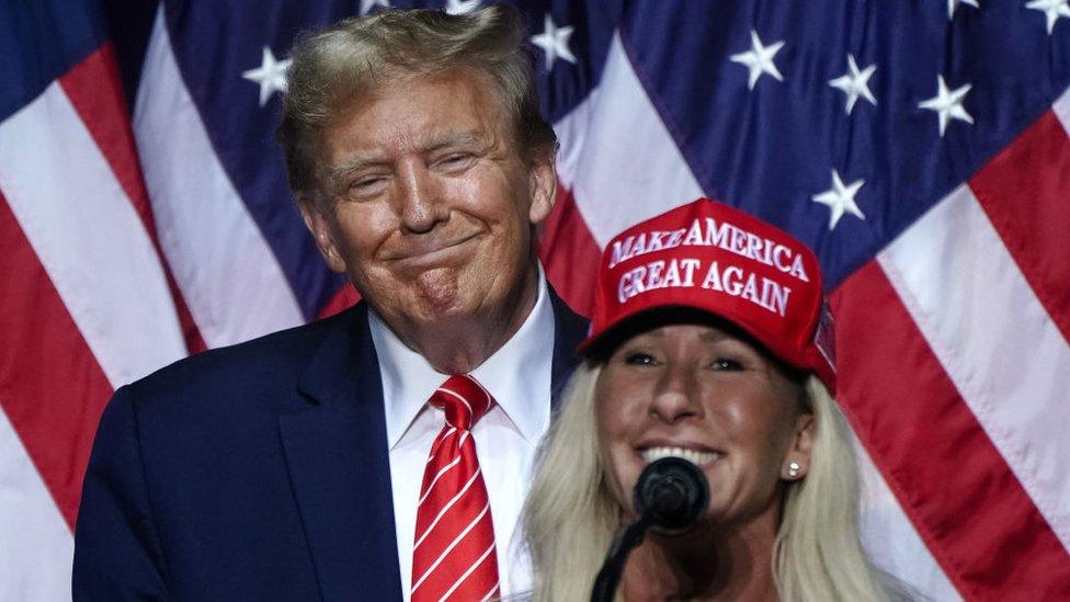 Donald Trump looks on as Marjorie Taylor Greene delivers remarks