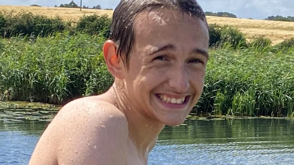 Alfie smiling while playing in a river